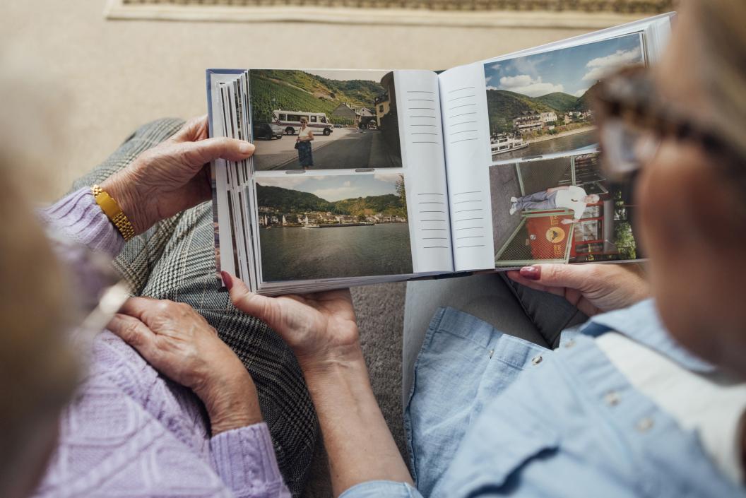 Senior elderly couple looking at travel photo album memories together